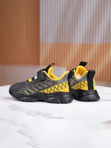 Detail view of breathable grey and yellow mesh children's sneakers with Velcro straps