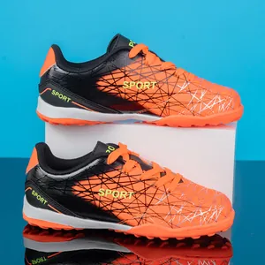 Orange and black kids' turf soccer shoes with wear-resistant synthetic leather upper