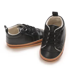 Close-up van zwarte PU-leren babysneakers met zachte antislip rubberen zolen