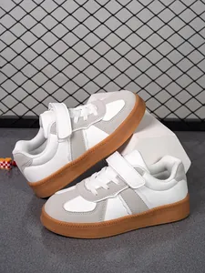 Vista detallada de zapatillas de skate blancas y grises para niños con suela de goma natural.
