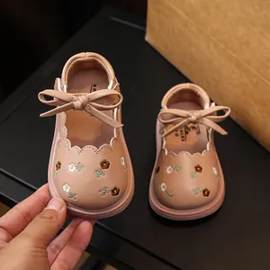Zapatos de cuero beige para niña pequeña con bordado de flores y detalle de lazo