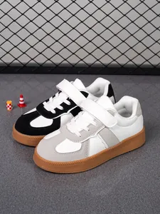 Vista detallada de las zapatillas informales para niños en blanco y negro y gris
