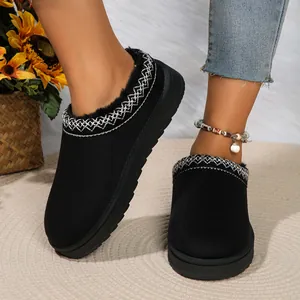 Detailopname van zwarte platform sneeuwschoenen met pluche voering en borduursels