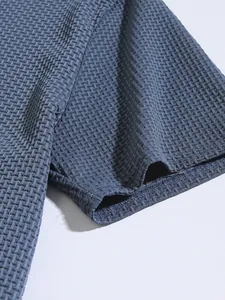 Detailed close-up showing the blue textured fabric and sleeve cuff of men's polo shirt
