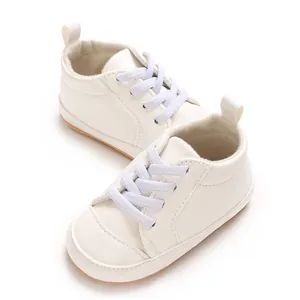 Detail van witte babysneakers van zacht PU-leer met comfortabele elastische veters.