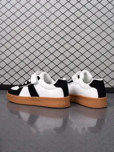 Vista trasera detallada de zapatillas infantiles en blanco y negro con suelas de goma