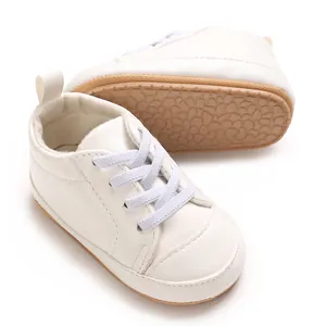 Detailopname van witte babysneakers met zacht PU-leer en antislip rubberen zool voor baby's