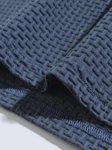 Close-up detail of the breathable textured fabric on men's athletic navy polo shirt