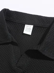 Detail view of black textured men's polo shirt showing collar and size label.