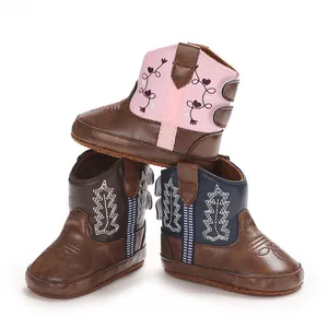 Vista dettagliata di eleganti stivali da cowboy per neonati in ecopelle rosa, marrone e blu navy