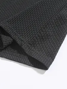Detailed close-up showing the black waffle knit texture of a men's athletic polo shirt