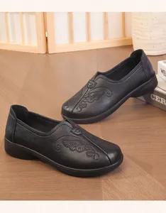 A detailed view of black embroidered loafers for elderly women with soft leather.