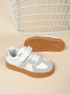 Vista detallada de zapatillas informales blancas y grises para niños con suela de goma