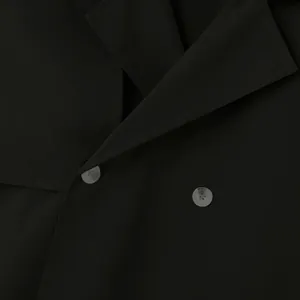 Macro view of black men's fashion short trench coat showing lapel detail and buttons