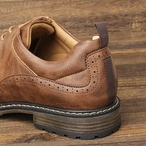 Close-up of brown leather business shoe heel featuring brogue details and a fabric pull tab.