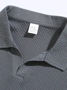 Detailed macro view of a grey textured polo shirt collar showing the size S material tag