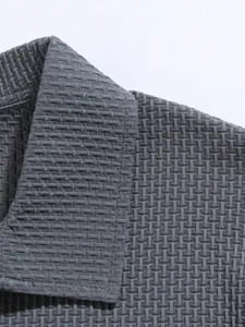 Close-up detail of gray textured fabric and lapel on men's athletic polo shirt