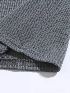 High-definition close-up of grey waffle textured stretch fabric on a men's sports polo shirt