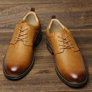 Detailed view of men's brown business dress shoes with burnished toe on wood background