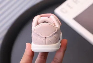 Close-up detail view of pink baby walking shoe with soft white non-slip rubber sole