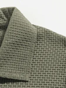 Close-up detail of textured waffle-weave fabric and collar on a men's polo shirt