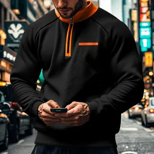 Nahaufnahme eines schwarzen und orangen Herren-Sweatshirts mit Stehkragen und Brusttasche