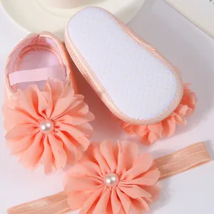Détail des chaussures de princesse roses pour bébé avec fleur en mousseline et bandeau