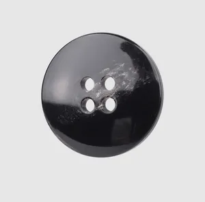 Macro detail of high-quality black four-hole resin button for luxury apparel and coats