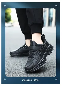 Close-up of black children's athletic sneakers with velcro strap and laces on pavement