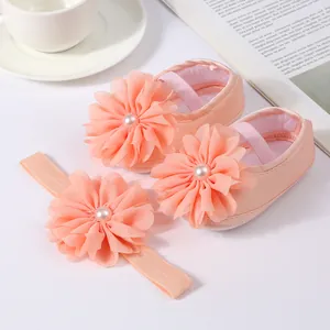 Détail de chaussures bébé roses et bandeau à fleur en mousseline assorti en gros plan