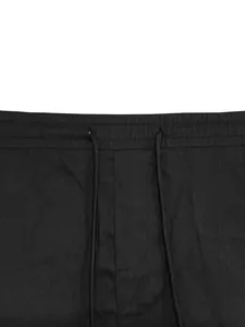 Dettaglio ravvicinato di pantaloncini cargo uomo con vita elastica e coulisse nera.