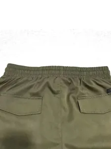 Dettaglio dell'elastico in vita e delle tasche posteriori con patta su pantaloncini cargo