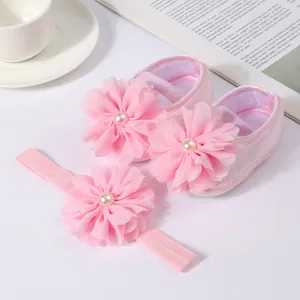 Détail des chaussures de princesse roses pour bébé et du bandeau à fleurs assorti