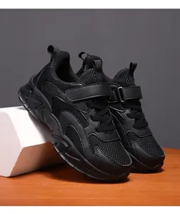 Detailed view of black breathable mesh children's sneakers featuring velcro straps