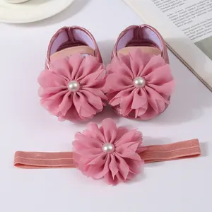 Détail des fleurs en mousseline rose et perles sur chaussures bébé et bandeau