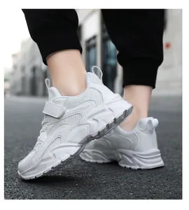 Close-up detail view of children's white breathable mesh sneakers on a city street