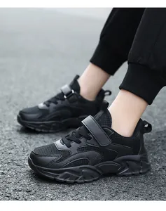 Close-up view of breathable black mesh children's sneakers featuring a secure Velcro strap
