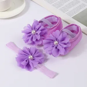 Détail de chaussures bébé violettes et bandeau avec d'élégantes fleurs en mousseline