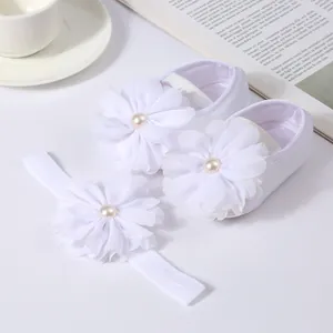 Vue détaillée de la fleur en mousseline et perle sur l'ensemble chaussures bébé blanc