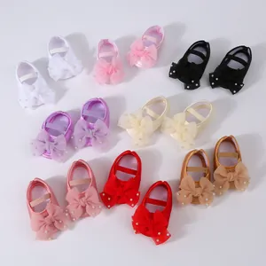 Close-up showing various colors of baby dress shoes with pearl mesh bow details
