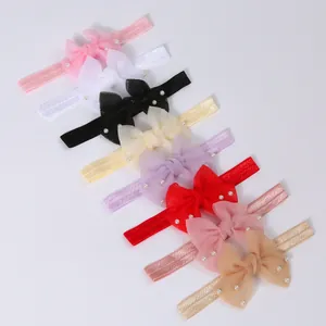 Macro view of colorful infant headbands featuring soft mesh bows and pearl accents