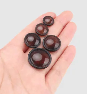 Close-up of high-end Japanese style amber resin buttons in hand showing multiple sizes.