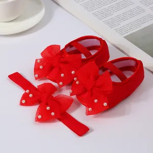 High-quality detail of red baby shoes and matching headband set with elegant pearl-beaded bows