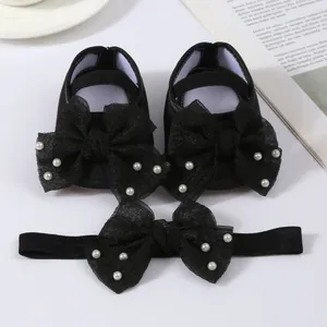 Detailed macro view of black baby shoe and matching headband set with mesh bows and pearls