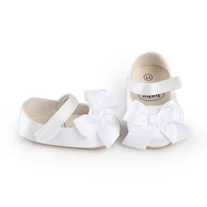 Detailed view of white satin baby walking shoes featuring elegant bow knot decoration