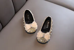 Exquisite Detailansicht der goldenen Prinzessinnenschuhe für Mädchen mit Perlen