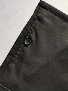 Detailansicht der schwarzen Cargohose mit Taschennähten und passendem Knopf.