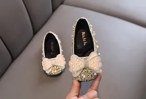 Detailansicht von Mädchen-Prinzessin-Schuhen mit funkelnden Strasssteinen und Perlenbogen
