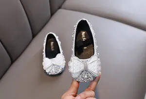 Nahaufnahme von funkelnden silbernen Prinzessinnenschuhen für Kleinkinder mit Perlen