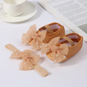 Detail of gold infant Mary Jane shoes and matching bow headband with pearls